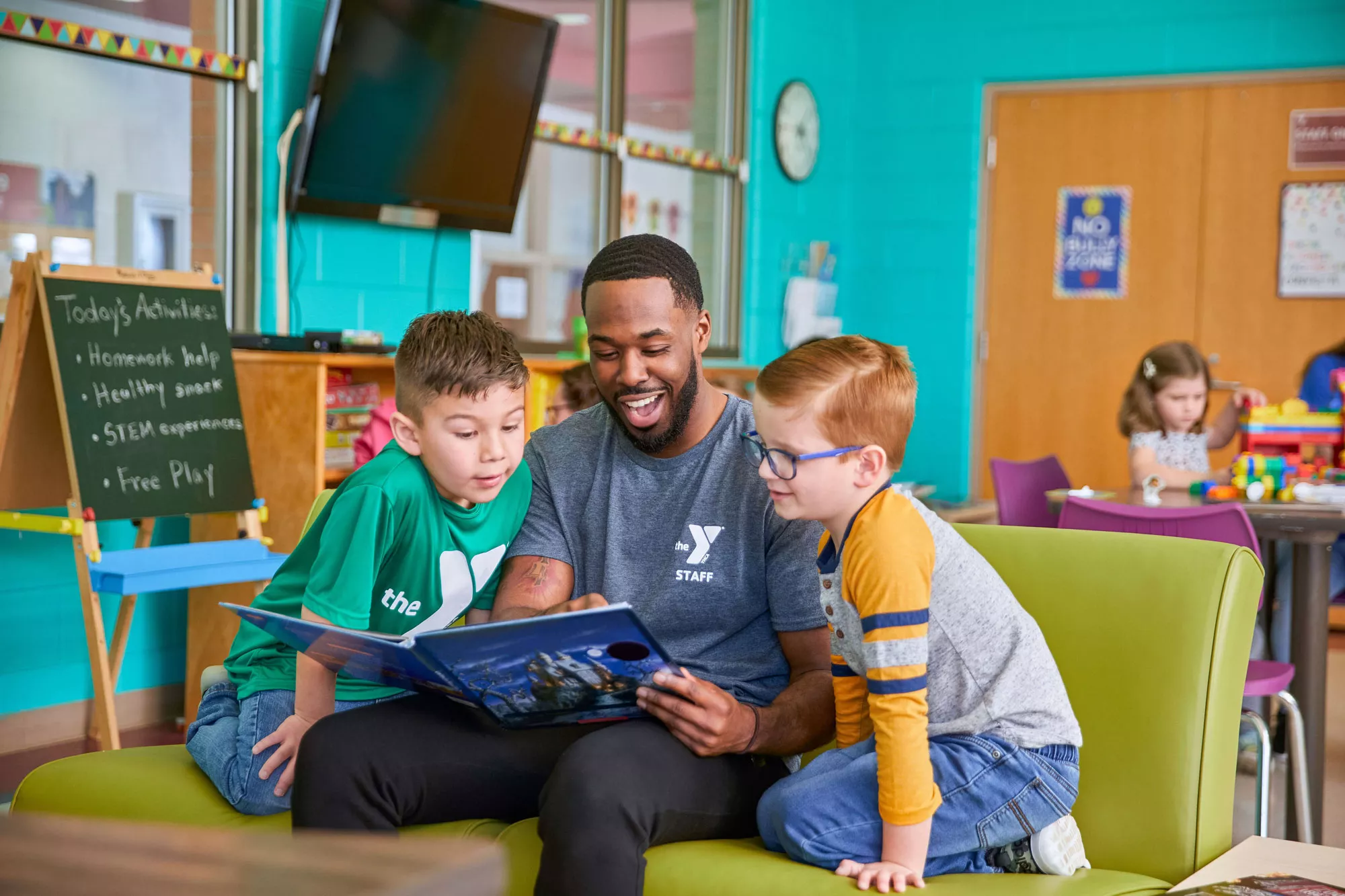 Adult reading a book to children at the YReads program